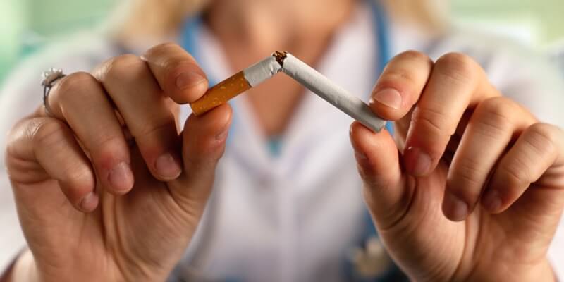 Mujer rompiendo un cigarrillo