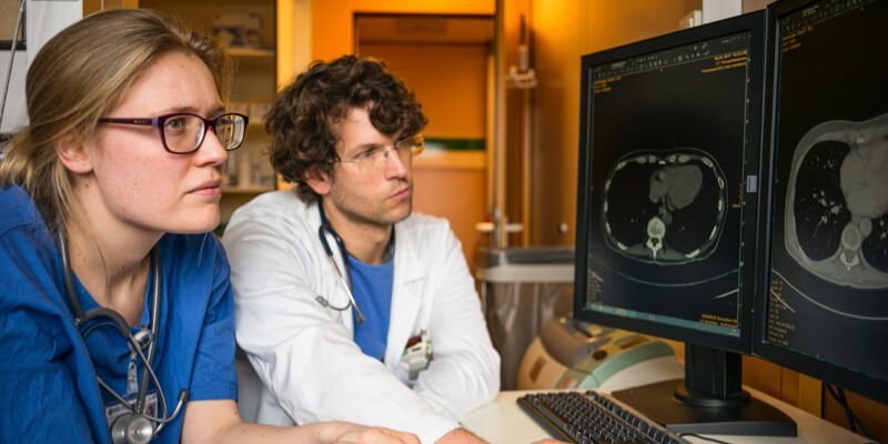 médicos mirando prueba radiológica