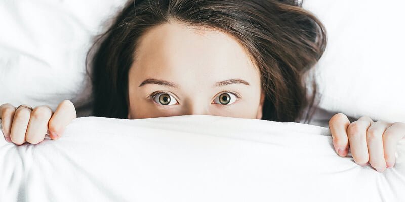 chica en la cama sin poder dormir