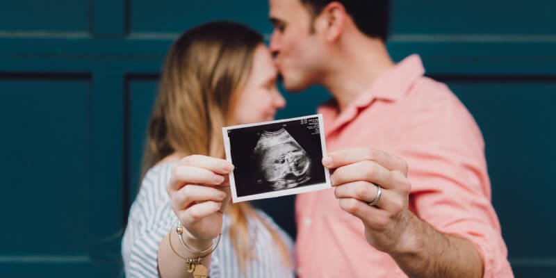 pareja mostrando una ecografía de su bebé