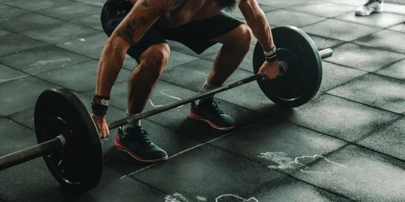 hombre en gimnasio levantando peso