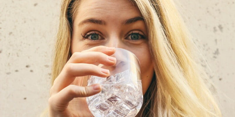 mujer bebiendo agua por hipo