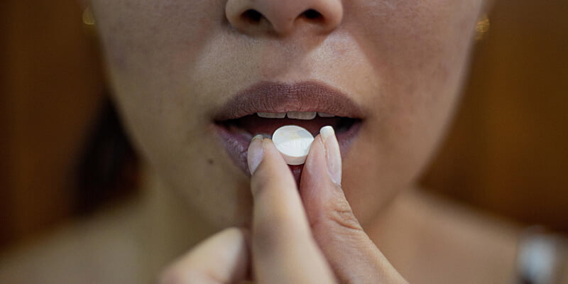 mujer tomando una benzocaina