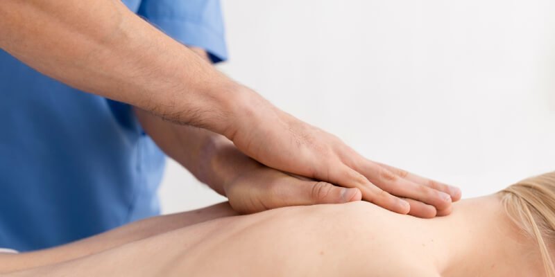masaje de fisioterapeuta en espalda de paciente